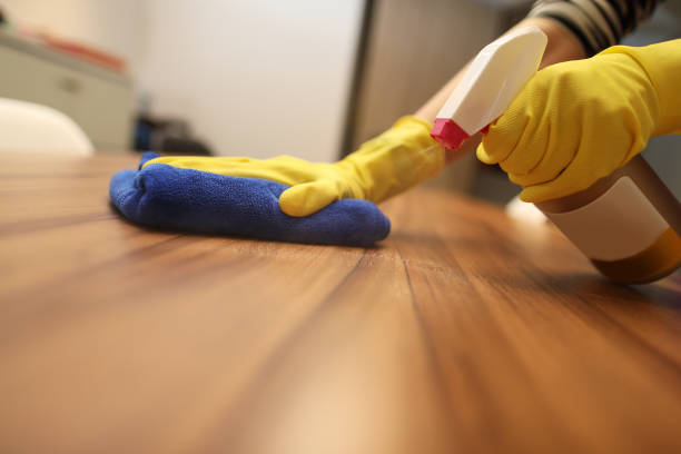 istock Woman wearing gloves cleaning desktop 1218727823