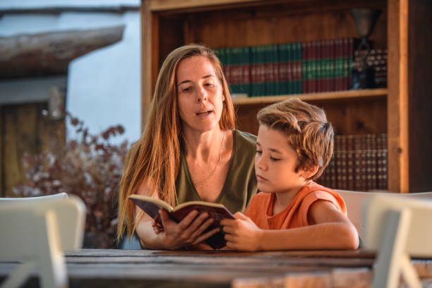 istock Smiling Mother Working with Young Son on His Reading 1218730374