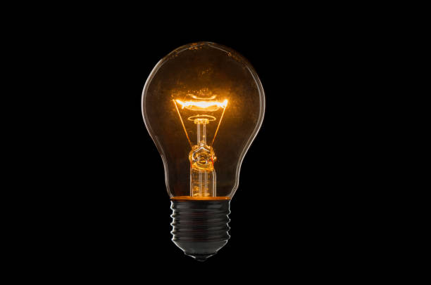istock Old, dirty light bulb close up on black background 1218731891