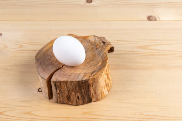 Chicken eggs on the cross sections of a tree trunk on a wooden table