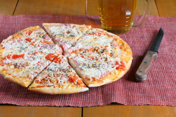 Cooked pizza and mug of beer.