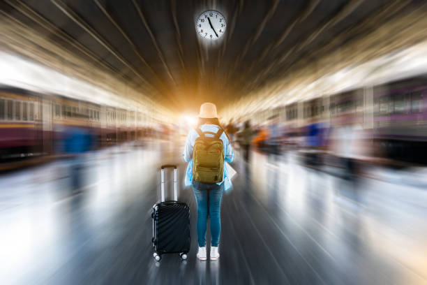 junge solo frau backpacker tourist warten abfahrt zeit uhr zu sommer abenteuer reise an der zug u-bahn-bahnhof mit verschwommenen bewegung geschwindigkeit bewegung abstrakte stadt beschäftigt überfüllt hintergrund - depart stock-fotos und bilder