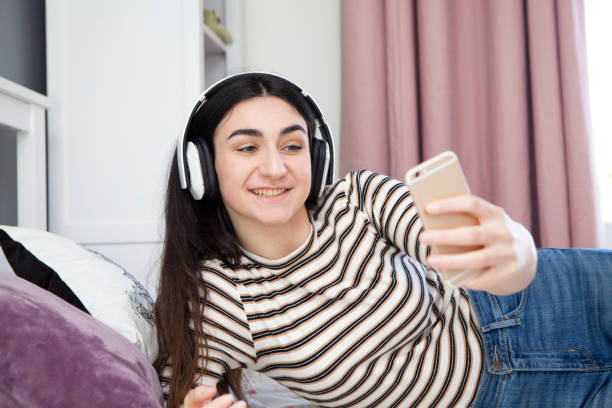 istock Teenager using smartphone in bedroom 1218736332