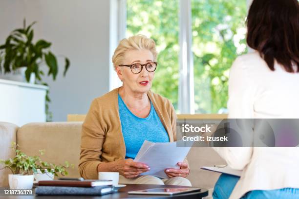 Worried Senior Woman Having Meeting With Financial Advisor At Home Stock Photo - Download Image Now