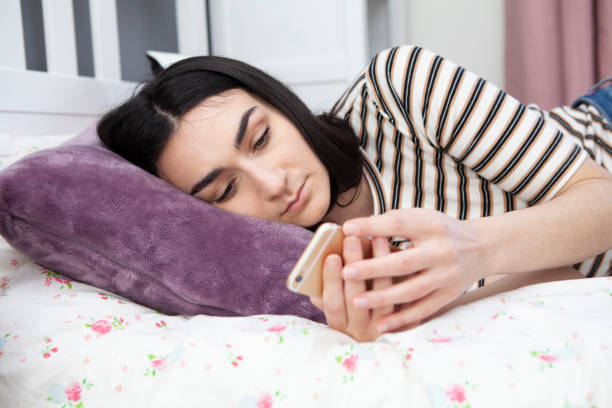 istock Teenager using smartphone in bedroom 1218736662