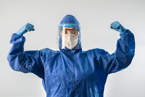 Healthcare worker woman wearing highly protective suit,  happy, brave and motivated.