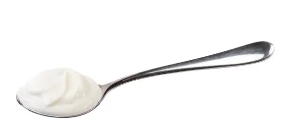Creamy swirl of natural yogurt in spoon