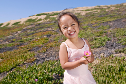 cute baby girl playing wit flower lavender in sunny summer day
