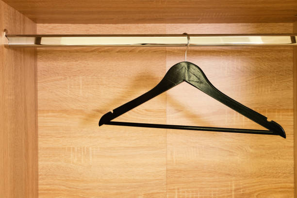istock Single empty black clothing rack hanging on coathanger in closet with copy space 1218740444