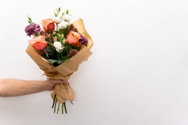Beautiful bouquet in hands hand on white background. Roses and chrysanthemums.Copy space