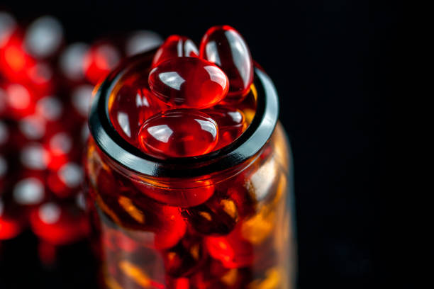 istock Red gel medical capsules on black background 1218742178