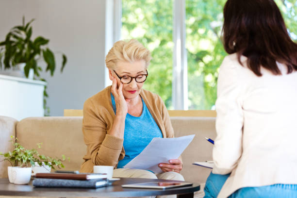 istock Confused elderly lady talking insurance agent at home 1218742190