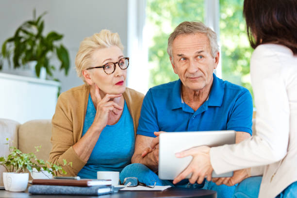 istock Elderly couple discussing with financial advisor at home 1218742611