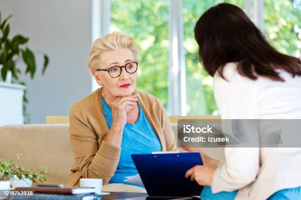 Insurance Agent Explaining Agreement To Senior Woman Stock Photo - Download Image Now