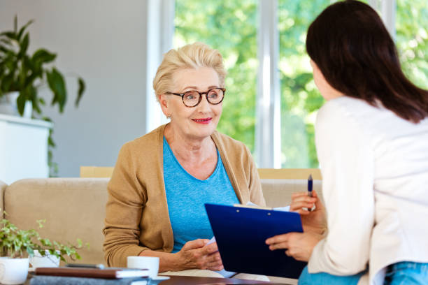 istock Insurance agent explaining agreement to smiling elderly lady 1218744067