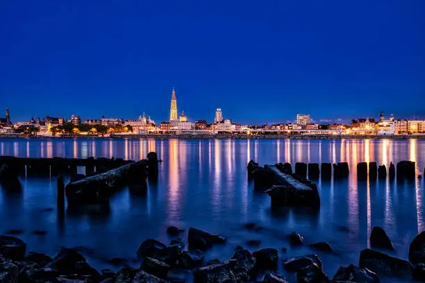 Skyline Antwerp, low water. The lights of Antwerp by night. Reflection of the lights in the Scheldt. Proud our lady cathedral in the skyline.
