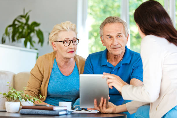 istock Senior couple discussing with insurance agent at home 1218745093