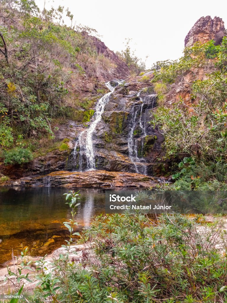 Sossego Waterfall in Serra do Cipo, Minas Gerais, Brazil Beautiful waterfall rolling across the stone wall in the mountains of Minas Gerais state, Brazil. This waterfall called Cachoeira do Sossego and located at Serra do Cipo region. Adventure Stock Photo