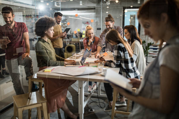 istock Large group of multi-tasking freelance workers at casual office. 1218747824