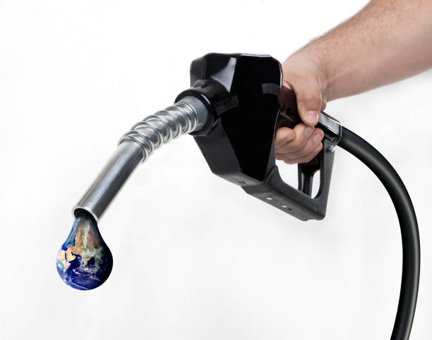 istock Black gas nozzle about to drip an earth 1218748431