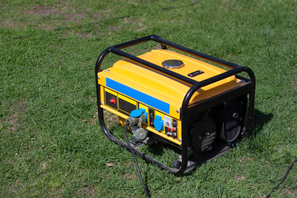 powerful portable gas or diesel generator to provide electricity. standing on the grass - gerador imagens e fotografias de stock