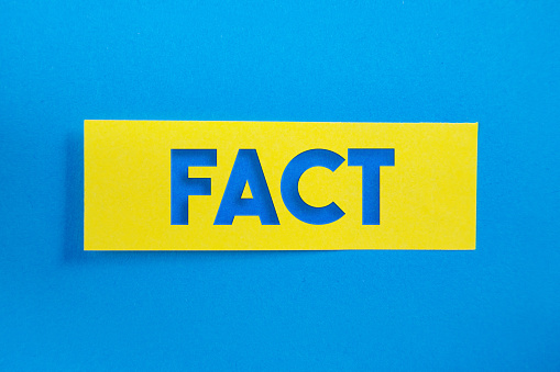 Yellow Sticky Paper With Fact Message On Blue Background. Horizontal composition with copy space.