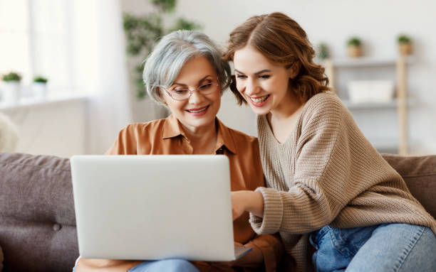 istock Young woman with mother using laptop at home 1218749902