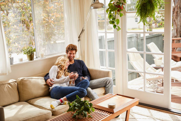 istock Young couple laughing over coffee while sitting at home 1218750387