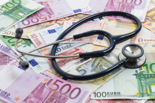 stethoscope lying on top of various euro banknotes. medical cost, insurance, wealth, health, education concept. - currency stethoscope medicare usa imagens e fotografias de stock