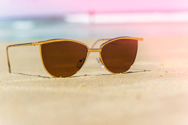 istock female sunglasses on a sandy beach by the sea 1218755964
