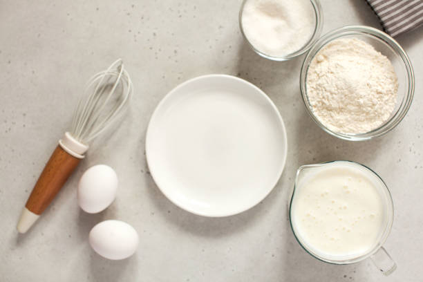 istock Ingredients for baking with flour and a cooking whisk with an empty white plate. The concept of food 1218756190