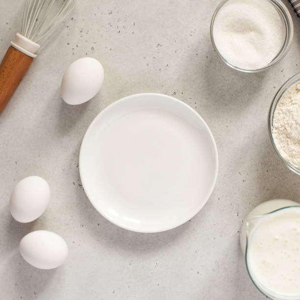 istock Ingredients for baking with flour and a cooking whisk with an empty white plate. The concept of food 1218756325