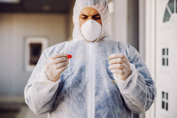 マスクを持つマスクを持つ保護スーツを着た男性は、サンプルバッカル綿棒と試験管を持ち、細胞からdnaを収集する準備ができています。コロナウイルスコビッド-19.感染予防と流行の制御.� - transgenic cotton ストックフォトと画像