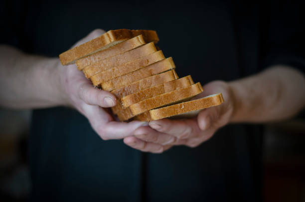 istock A man holds a chopped loaf of bread in his hands. 1218757895