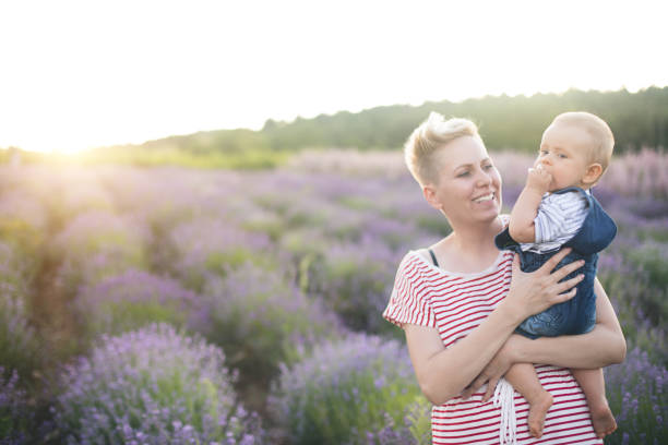 istock Happy mother with little son playing on lavender field 1218757914