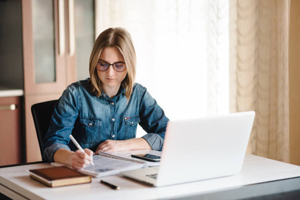 istock Home work. Woman working, learns and using laptop computer on table in home office. Freelance. Writing, typing. Communication and technology concept. Paperwork. 1218758849