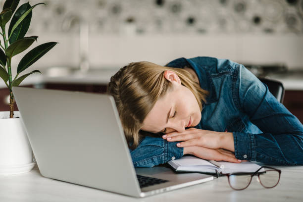 istock Tired business woman working at home, headache and falling asleep at work. Home work. Learns, using laptop computer on table. Freelance. Writing, typing. Technology concept. Paperwork. 1218758861