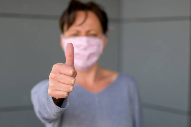 istock Woman wearing a face mask doing a thumbs up 1218759007