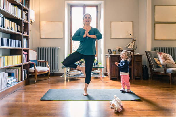 istock doing yoga at home with a young daughter 1218759058