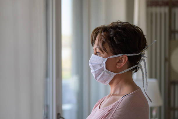 istock Woman wearing a protective face mask indoors 1218759078