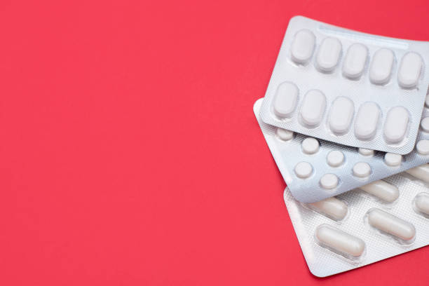 píldoras ampollas sobre fondo rojo con un espacio de copia - hormone therapy hrt pill medicine fotografías e imágenes de stock