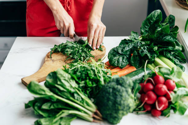 istock woman cuts greens 1218759757