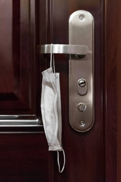 istock used medical mask hangs on the door handle 1218760983