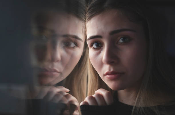 istock unhappy woman crying at the window 1218761261