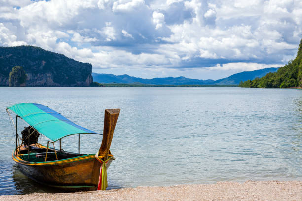 View landscape seascape and clouds sky wave in sea ocean and thai fisher people stop wooden fishing boat or wood fishery ship wait catch fish and marine life on Phetburi Beach in Phetchaburi, Thailand