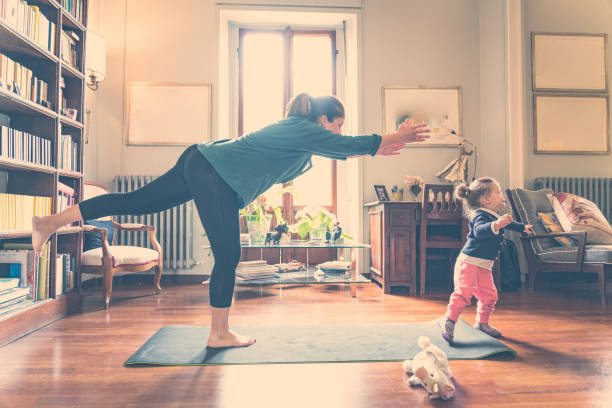 istock woman staying at home exercising with her daughter 1218763073