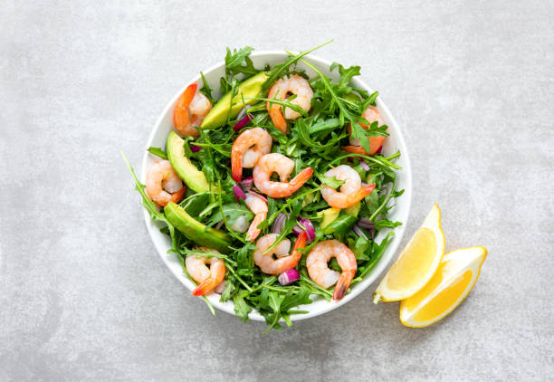 ensalada de rúcula de camarones con rodajas de aguacate, vista de alto ángulo de plato listo para comer - salad shrimp prawn prepared shrimp fotografías e imágenes de stock