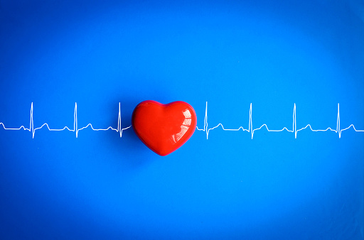 Image of Red Heart with White EKG Line On blue background. Healthcare photo content.