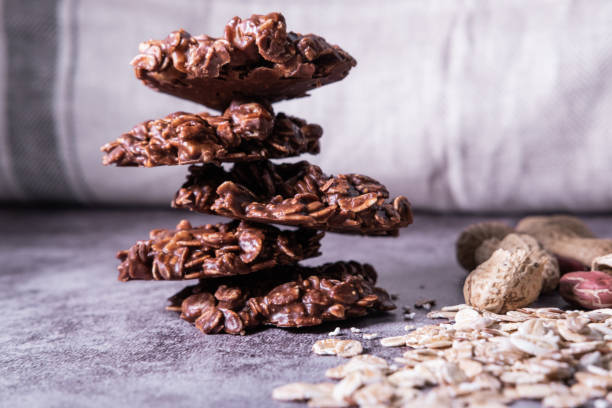 zdrowe ciasteczka owsiane bez pieczenia wykonane z masłem orzechowym i proszkiem czekoladowym. wegańska przekąska. widok z bliska. - cookie sugar oatmeal isolated zdjęcia i obrazy z banku zdjęć