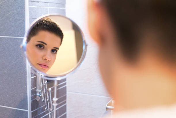 istock Woman looking at herself in the bathroom mirror 1218769659